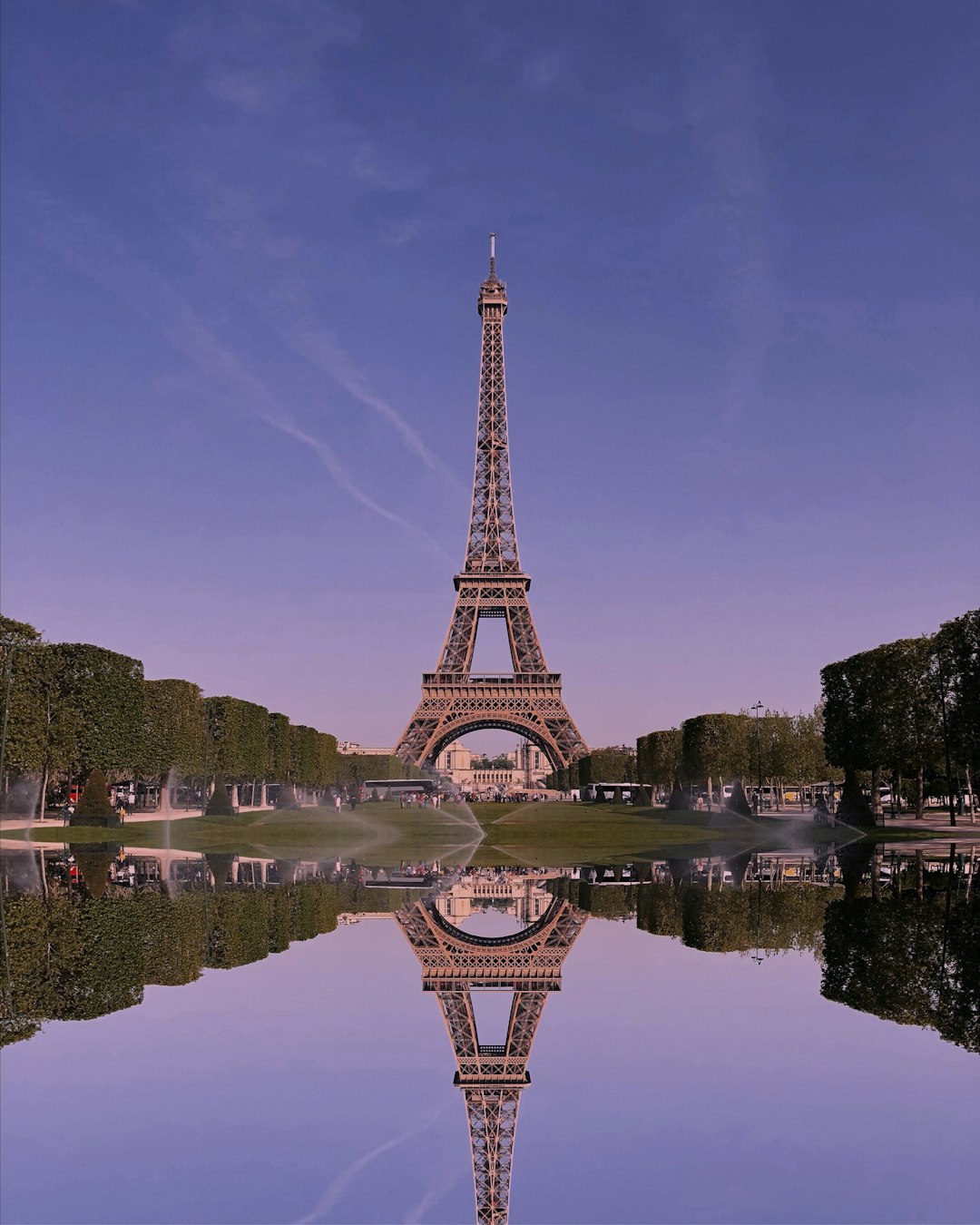 Torre Eiffel reflejada en un estanque al atardecer.